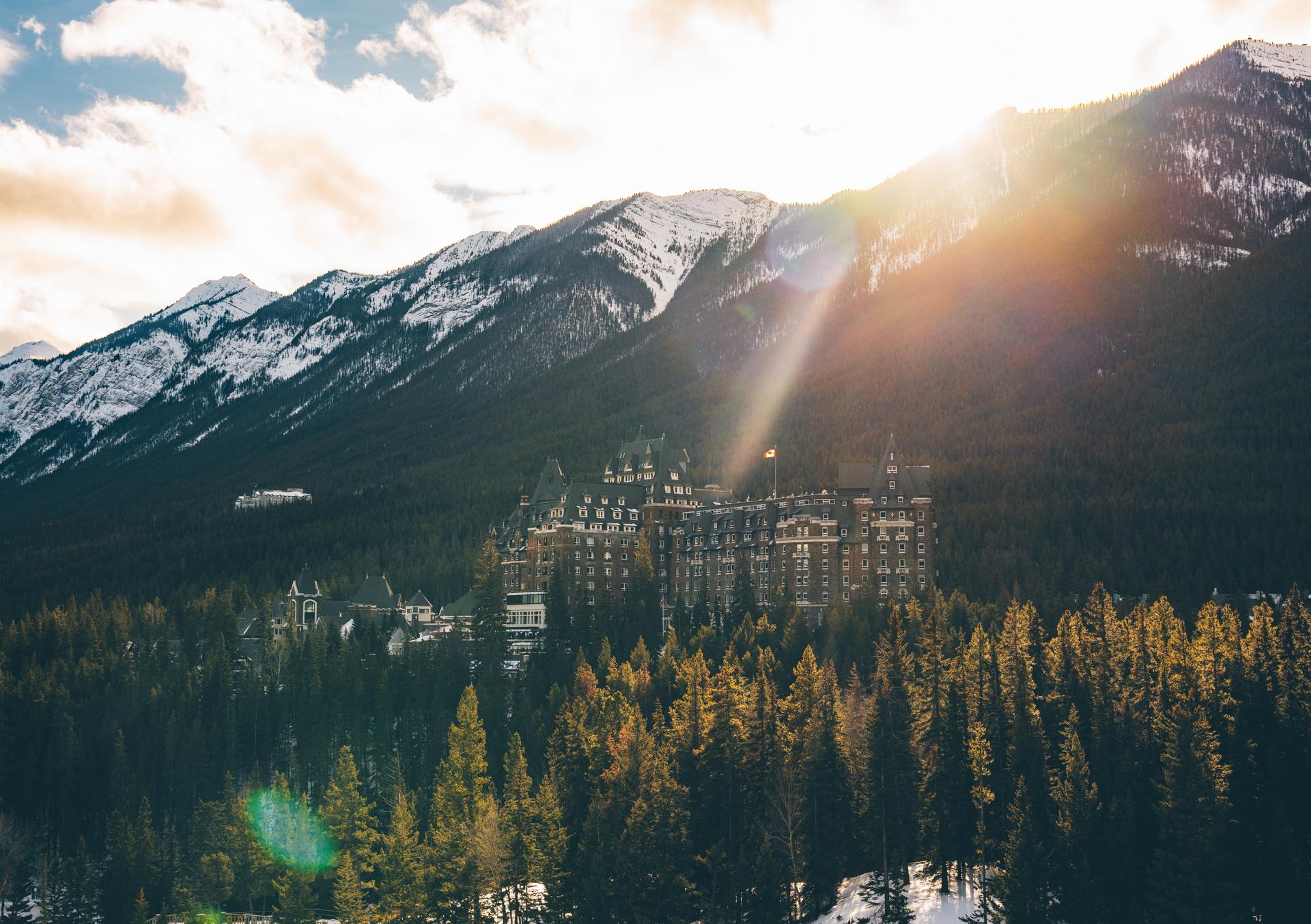 A grand castle-like hotel nestled among pine trees in Banff, Alberta