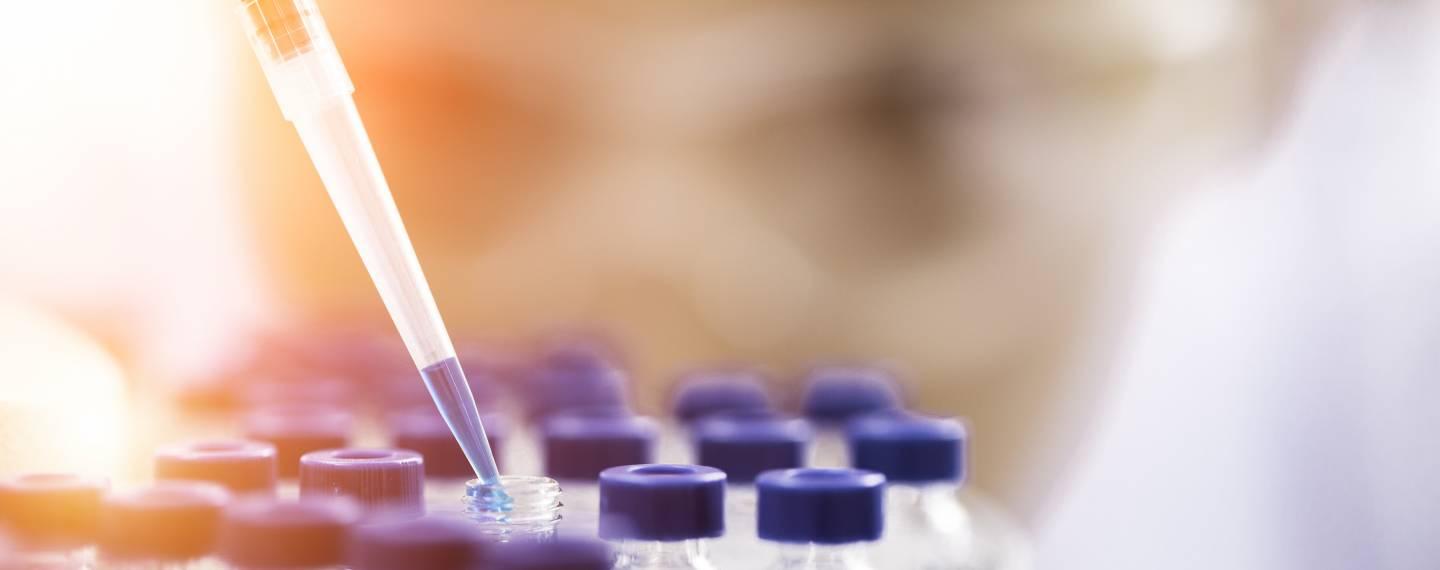 A dropper fills a bottle with medicine